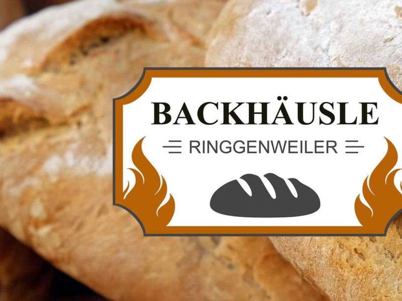 Im Hintergrund ein frisch gebäackener Brotlaib, im Vordergrund das Logo der Initiative "Backhäusle Ringgenweiler"