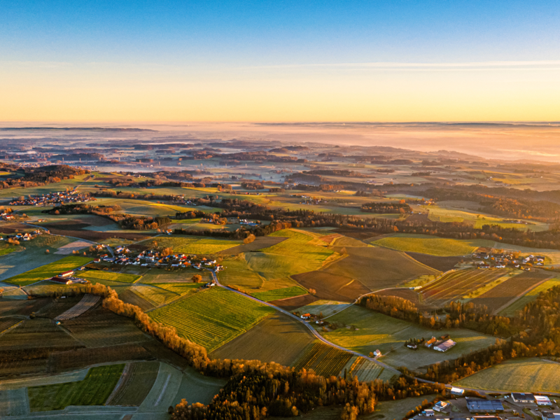 Luftaufnahme Landschaft von Horgenzell mit vielen Grünflächen und einzelnen Wohnplätzen, das Foto ist zum Tagesende aufgenommen, sodass melancholische Stimmung entsteht