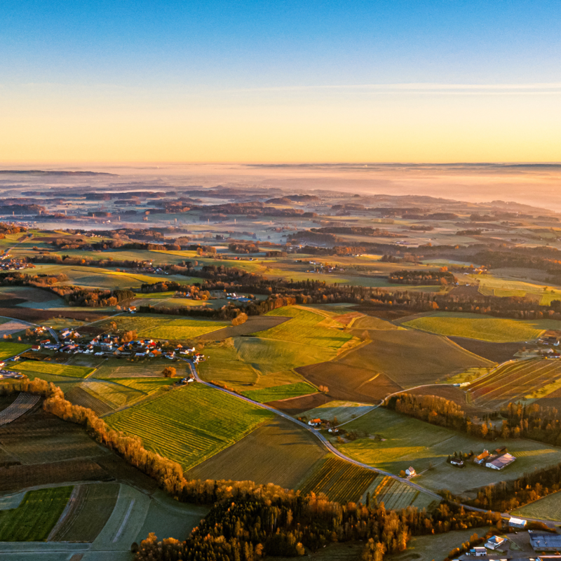 Luftaufnahme Landschaft von Horgenzell mit vielen Grünflächen und einzelnen Wohnplätzen, das Foto ist zum Tagesende aufgenommen, sodass melancholische Stimmung entsteht