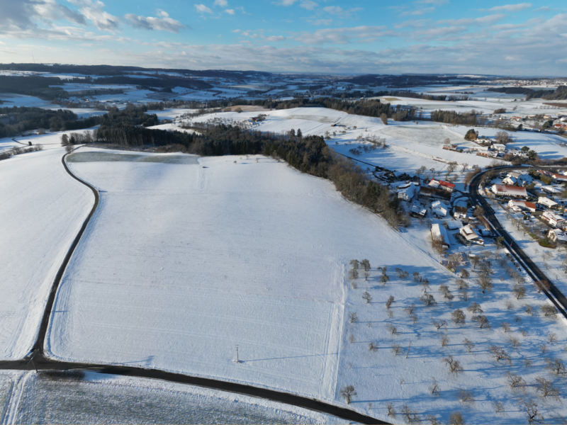 Winterliche Luftaufnahme mit schneebedeckter Landschaft, die Aufnahme soll die Fläche des zukünftigen Standorts des Gewerbegebiet Ringgenweiler darstellen