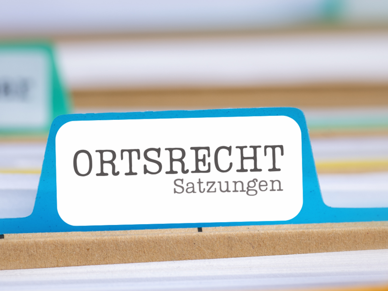 Die Detailansicht von einem Hängeregister. Jedes Register ist beschriftet und hat eine anders farbige Mappe. Die Beschriftung mit der Aufschrift "Oersrecht" ist scharfgestellt, die restlichen sind in der Aufnahme unscharf und daher nicht lesbar.