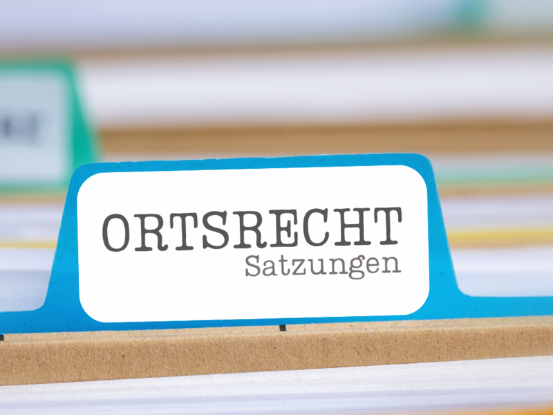 Die Detailansicht von einem Hängeregister. Jedes Register ist beschriftet und hat eine anders farbige Mappe. Die Beschriftung mit der Aufschrift "Oersrecht" ist scharfgestellt, die restlichen sind in der Aufnahme unscharf und daher nicht lesbar.